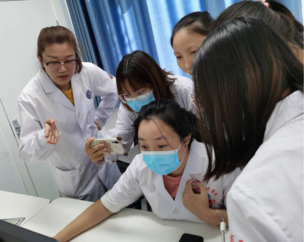 图2-在我院专家李欣颖的指导下，永和县人民医院放射科技师独立操作扫描.jpg